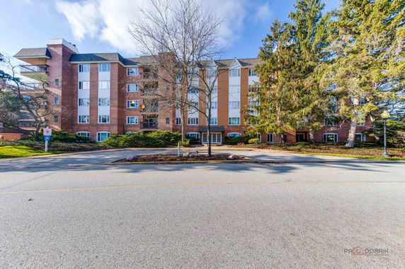 Front view of a multi-story residential building with brick and panel exterior.