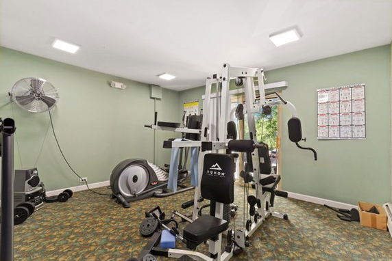 Indoor gym area with exercise equipment and machines.
