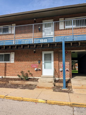 Front view of a two-story brick building with a balcony.