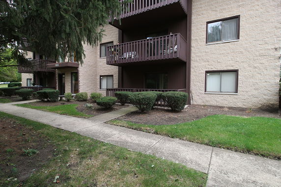 Front view of an apartment building with a beige facade and multiple balconies.