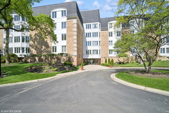 Front view of a multi-story residential building with a brick facade and multiple windows.
