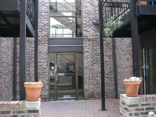 Brick exterior view of a building entrance with a glass door.