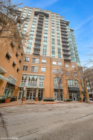 Front view of a multi-story residential building with large glass windows and balconies.