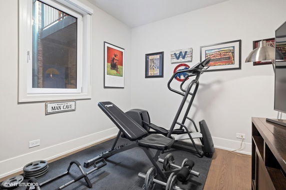 Home gym room with exercise equipment and wall decorations.