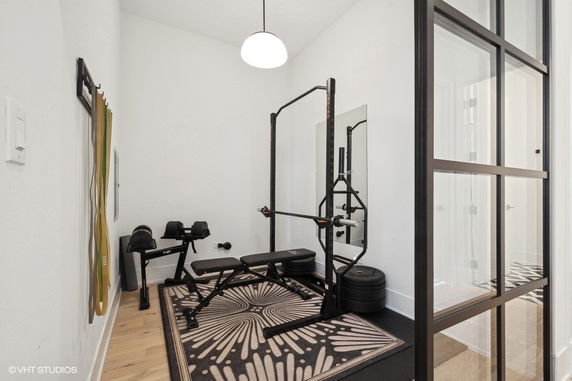 Indoor gym area with exercise equipment including a bench press and weights