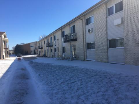 Front view of a two-story residential building with balconies and air conditioning units.
