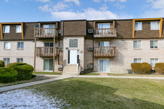 Front view of a multi-story residential building with balconies.