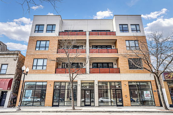 Front view of a multi-story building with large windows and balconies.