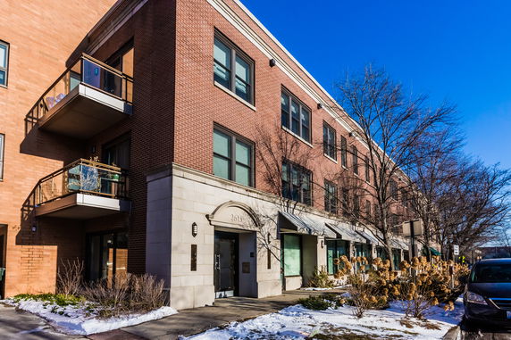 Front view of a three-story brick building with balconies.