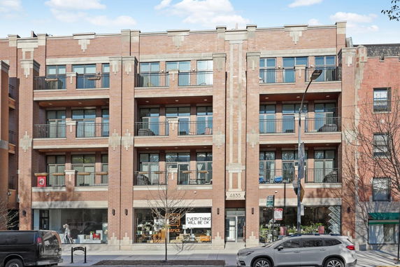 Front view of a multi-story brick building with large windows and balconies.