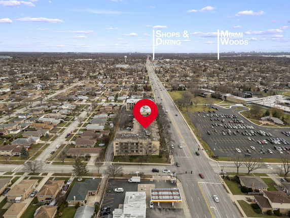 Panoramic view of a suburban area with a main road running through it, visible from above.