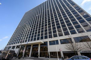 Front view of a large multi-story office building with a grid-like window pattern.