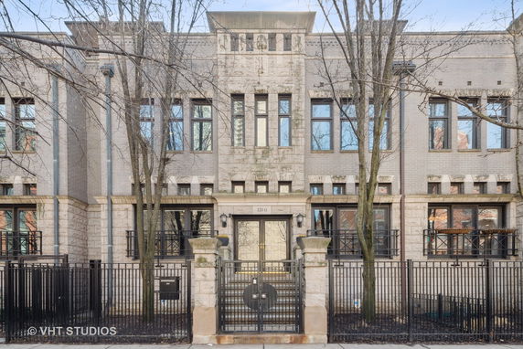Front view of a multi-story building with a gated entrance.