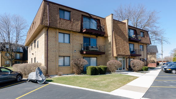 Front view of a three-story apartment building with balconies.