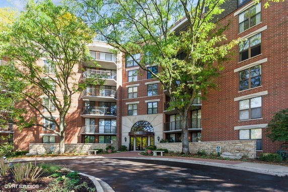 Front view of a multi-story brick residential building with balconies.