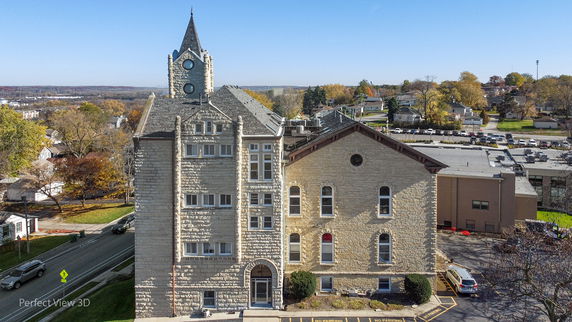 Front view of a multi-story stone building with a clock tower.