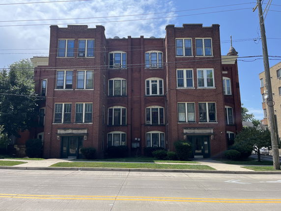 Front view of a multi-story brick apartment building.