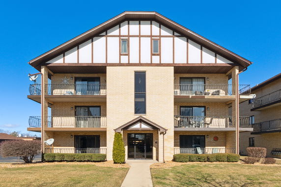 Front view of a three-story apartment building with balconies.