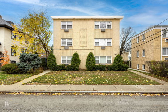 Front view of a three-story apartment building with brick exterior.