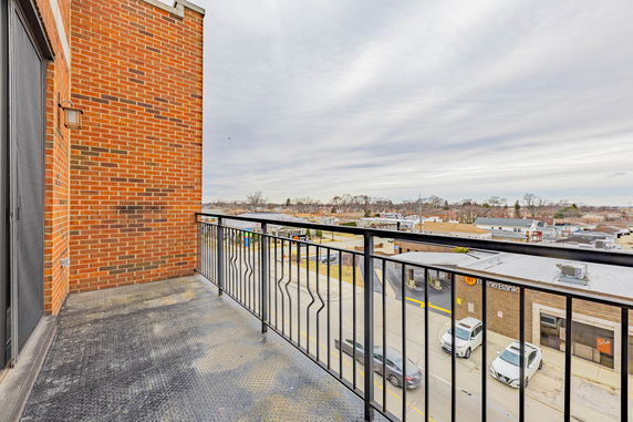 Balcony view overlooking a street and surrounding buildings.