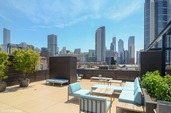Rooftop with seating area overlooking a city skyline.