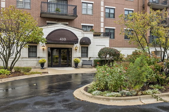 Front view of a multi-story brick building with balconies and a covered entrance.