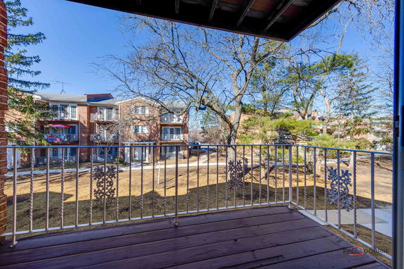 View from a balcony showing multiple apartment buildings and trees.
