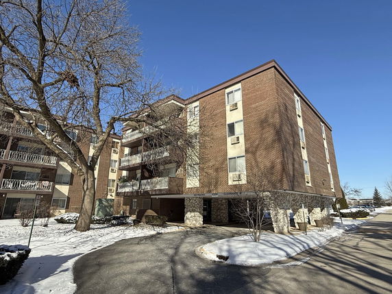 Front view of a multi-story apartment building with balconies.