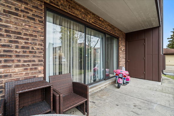 Side view of a house with a brick exterior and large sliding glass doors.