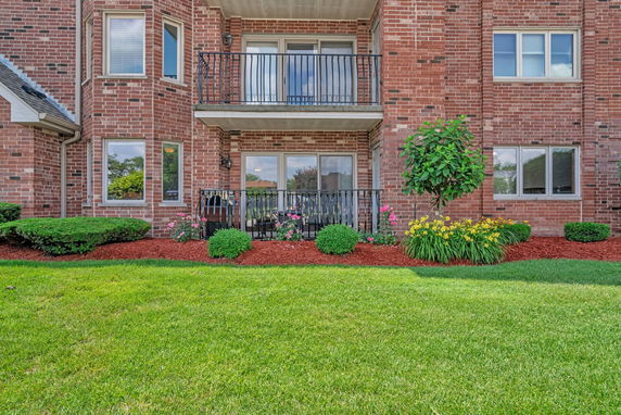 Front view of a brick residential building with balconies.