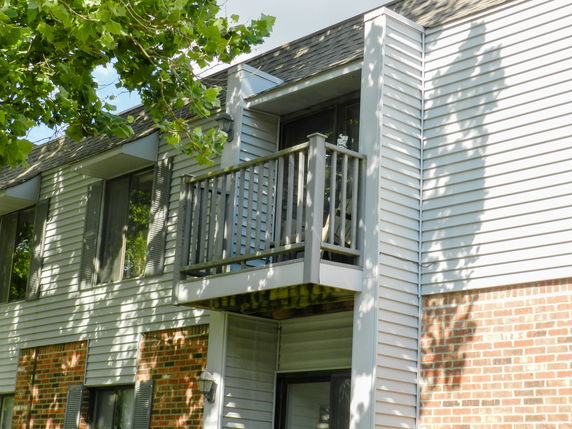 Front view of a building with a small balcony and brick facade.