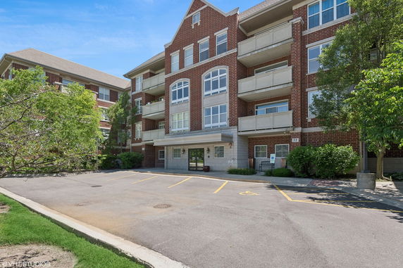 Front view of a multi-story brick building with balconies.