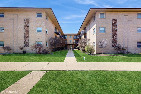Front view of a three-story apartment building with balconies.