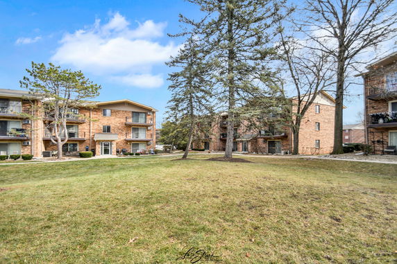 Front view of a brick apartment building with balconies.