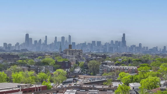 Wide angle view of a city skyline with tall buildings and greenery.
