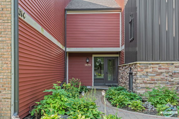 Entrance of a red house with a combination of brick and siding exterior.