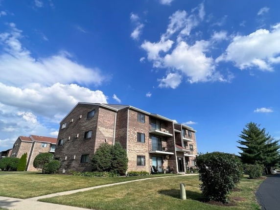 Front view of a multi-story brick apartment building.