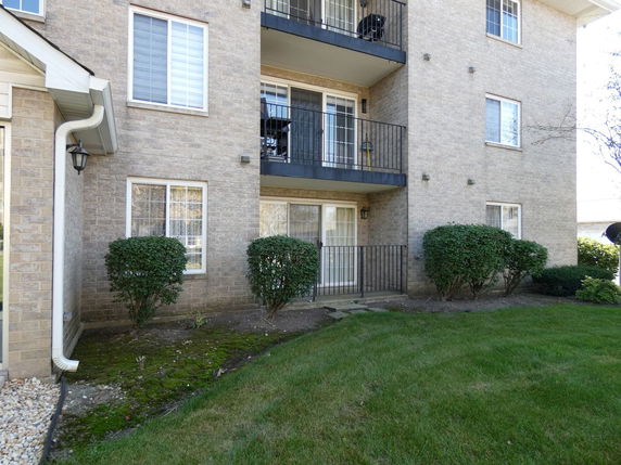 Front view of a multi-story building with brick exterior and balconies.