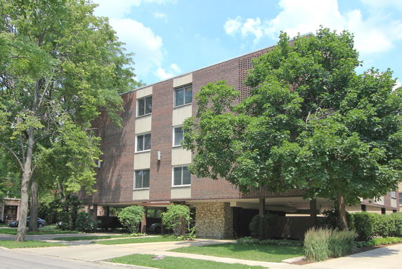 Front view of a multi-story brick building with trees.
