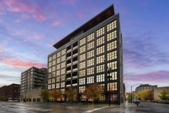 Front view of a modern multi-story building with large windows.