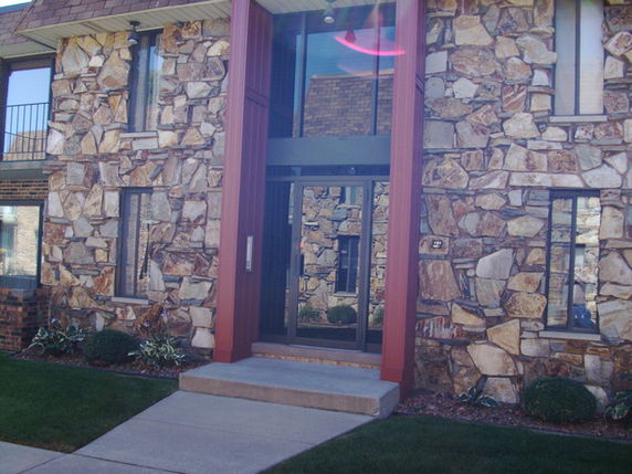Front view of a building with stone exterior and large glass entrance.