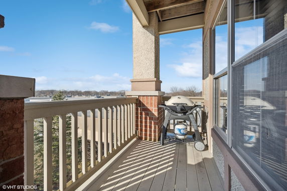 View from a balcony showing surrounding rooftops and distant trees.