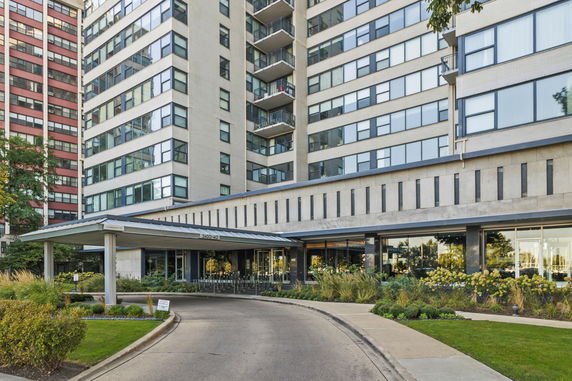 Front view of a multi-story building with balconies and a covered entrance.