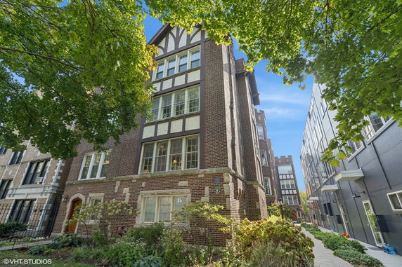 Front view of a multi-story brick building with large windows and decorative detailing.