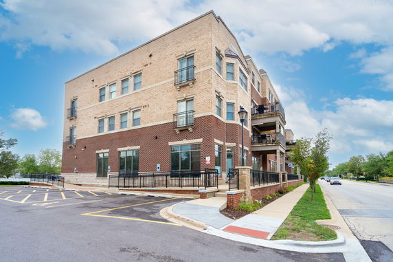 Front view of a multi-story building with brick exterior and balconies.