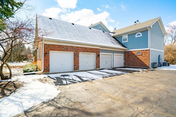 Front view of a house with triple garage and snow-covered driveway.