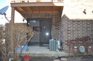 Back view of a building with a glass door and brick walls.
