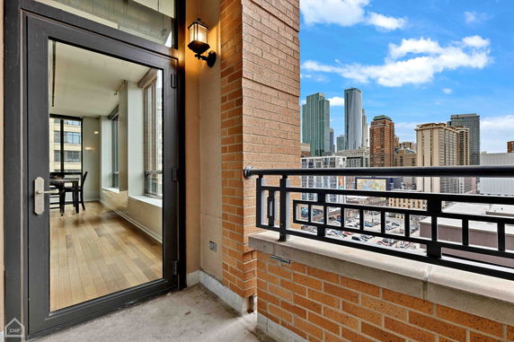 View from a balcony overlooking a cityscape with tall buildings.