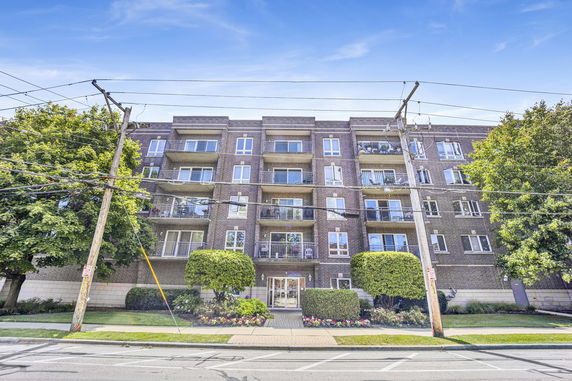 Front view of a multi-story residential building with balconies.