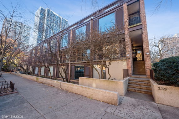 Front view of a multi-story building with large windows and a brick exterior.